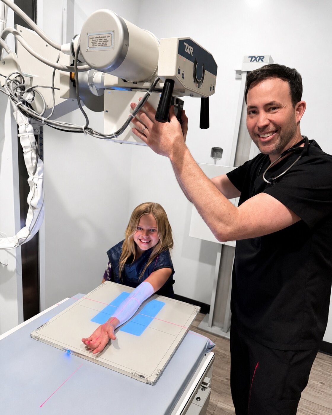 Dr. Brenden McRae positioning a young patient's arm for an on-site X-ray